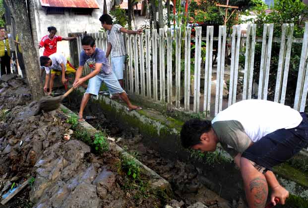 Teddy Lianto BANGKIT DAN BERGOTONG ROYONG. Relawan Tzu Chi menggerakkan warga korban banjir Manado untuk bergotong royong membersihkan lingkungan dan tempat tinggal mereka (atas).